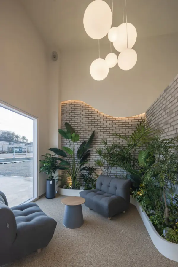 초록 식물과 곡선 브릭월이 어우러진 힐링 카페